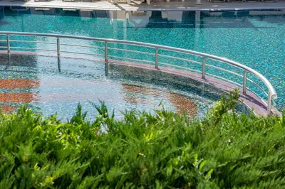 a swimming pool with a metal railing in the water at Rainbow 3 - Menada Apartments in Sunny Beach