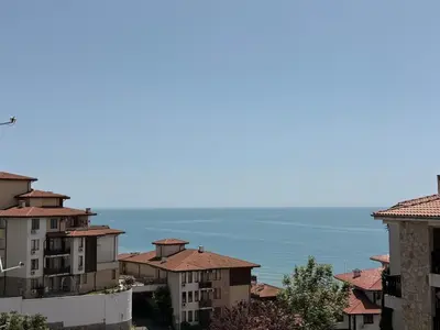 a group of buildings with the ocean in the background at Stylish studio near harbor and luxury beach in Sveti Vlas