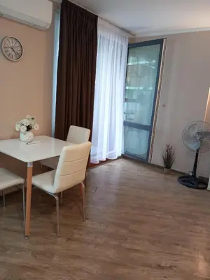 a dining room with a table and chairs and a window at Силви Съни Бийч Плаза in Sunny Beach