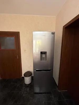 a stainless steel refrigerator in the corner of a room at Pomorie S&T Home in Pomorie