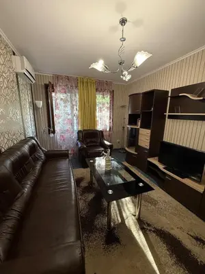 a living room with a leather couch and a coffee table at Pomorie S&T Home in Pomorie