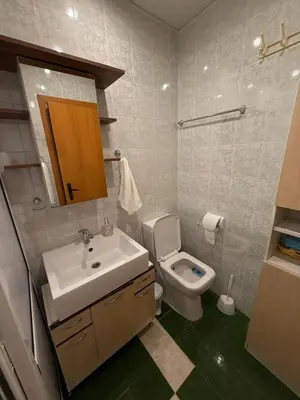 a bathroom with a sink and a toilet and a mirror at Pomorie S&T Home in Pomorie