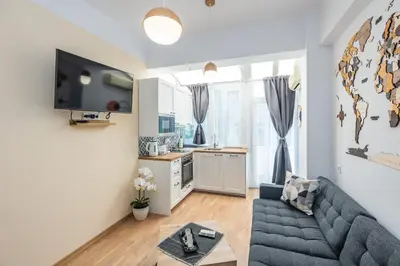 a living room with a blue couch and a kitchen at California in Varna City