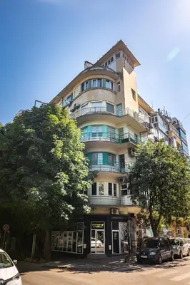 a tall building with cars parked in front of it at California in Varna City