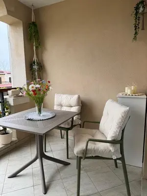 a table and chairs with a vase of flowers on it at Dream Life Sozopol in Sozopol