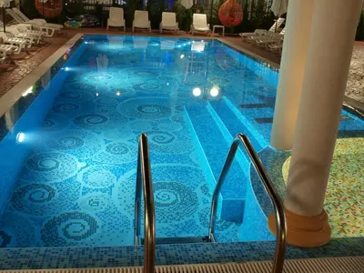 a swimming pool with a blue tile floor and stairs at Apart Sweet Homes 5 - Apartments for guests in Sunny Beach