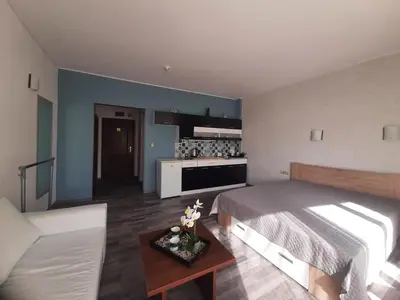 a bedroom with a bed and a table and a kitchen at Sunshine2 in Sunny Beach