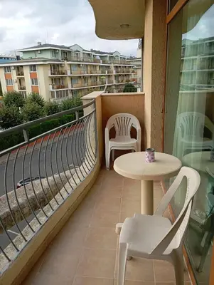 a balcony with a table and chairs and a building at Sunshine2 in Sunny Beach