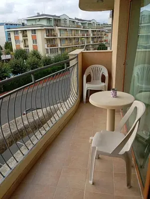 a balcony with a table and chairs and a building at Sunshine2 in Sunny Beach
