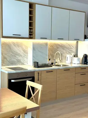 a kitchen with wooden cabinets and a sink at Byala sea view apartment Studio in Byala