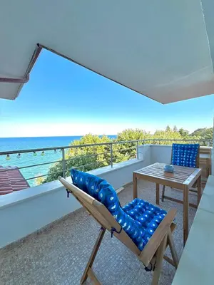 a balcony with a chair and a table and the ocean at Byala sea view apartment Studio in Byala