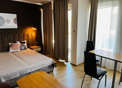 a bedroom with a bed and a desk and a table at Blue Bay House in Nesebar