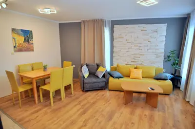 a living room with a yellow couch and a table at Blue Bay House in Nesebar
