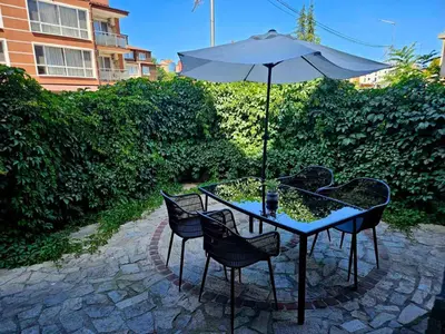 a table with an umbrella and chairs on a patio at Blue Bay House in Nesebar