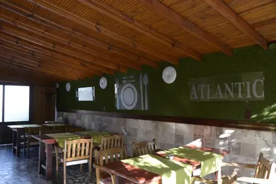 a restaurant with tables and chairs and a green wall at Atlantic Complex Ravda in Ravda