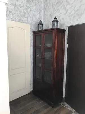 a wooden cabinet with glass doors in a room at Burgas Biju in Burgas City