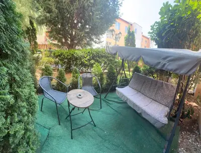 a patio with a couch and chairs and a table at Monte Carlo Vaio - 1BR Garden Apt - With Direct Pool Access in Sunny Beach