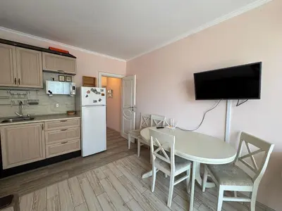 a kitchen and dining room with a table and a refrigerator at VP Villa Valencia in Sunny Beach