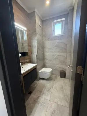 a bathroom with a toilet and a sink and a window at Aurum Villas Smokinya Beach 4 in Sozopol