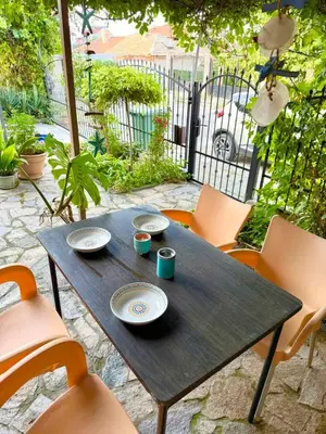 a wooden table with plates and cups and chairs at Apartment in Desi's house in Obzor