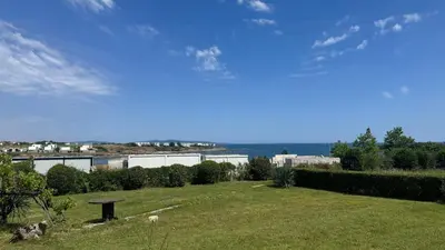 a grassy field with a view of the ocean at Къща за гости тип Бунгало Арапя, Царево in Tsarevo