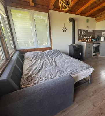 a large bed in a room with a kitchen at Къща за гости тип Бунгало Арапя, Царево in Tsarevo