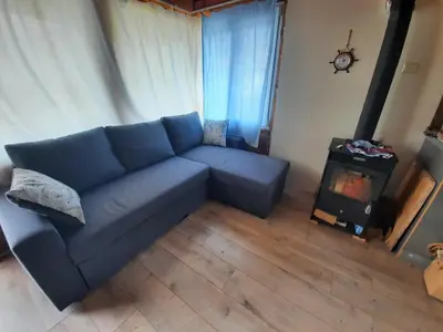 a blue couch in a living room with a stove at Къща за гости тип Бунгало Арапя, Царево in Tsarevo