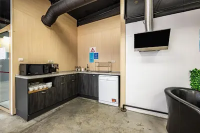 a kitchen with a refrigerator and a tv on a wall at Heart of the city Hostel in Varna City