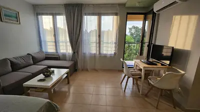 a living room with a couch and a desk with a television at Studio Vanita in Sozopol