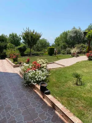 a garden with a bunch of flowers on a path at Стаи за гости Денкови in Burgas City