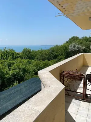 a balcony with a table and a view of the ocean at Стаи за гости Денкови in Burgas City