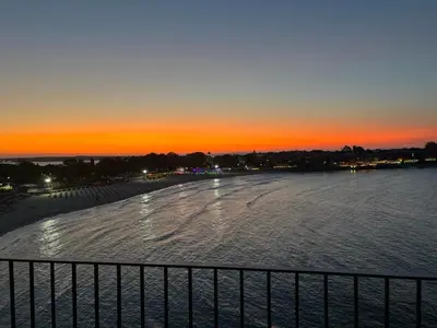 a view of a beach at sunset with a fence at Магията на Созо in Sozopol