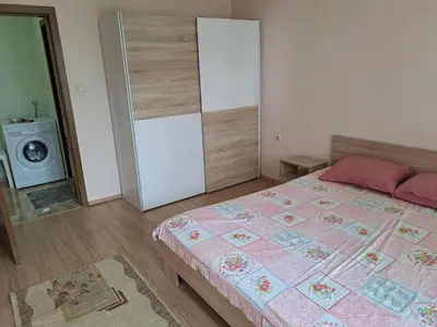 a bedroom with a bed with a pink quilt at Двустаен апартамент в Славейков in Burgas City