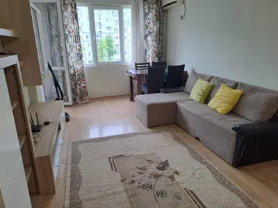 a living room with a couch and a table at Двустаен апартамент в Славейков in Burgas City