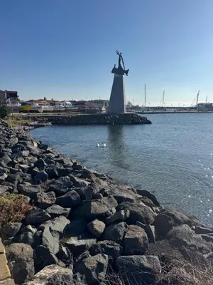 a lighthouse on the shore of a body of water at Windmill Nessebar studio with sea view in Nesebar