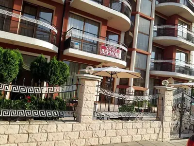 an apartment building with an umbrella in front of it at Семеен хотел Вермона in Primorsko