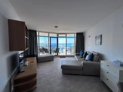 a living room with a couch and a television at Vega Stevi Vlas - Beachfront in Sveti Vlas