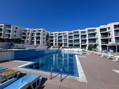 a swimming pool in front of a large apartment building at Vega Stevi Vlas - Beachfront in Sveti Vlas