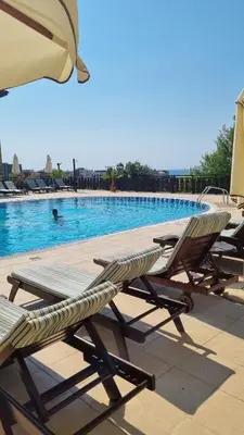 a group of lounge chairs sitting next to a swimming pool at Studio in Relax Complex, Sveti Vlas in Sunny Beach