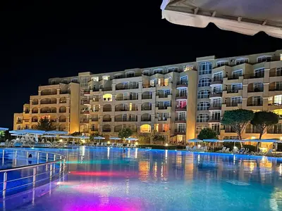 a large building with a swimming pool at night at Black Sea Residence Aheloy in Aheloy