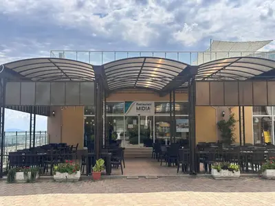 a restaurant with tables and chairs in front of a building at Black Sea Residence Aheloy in Aheloy