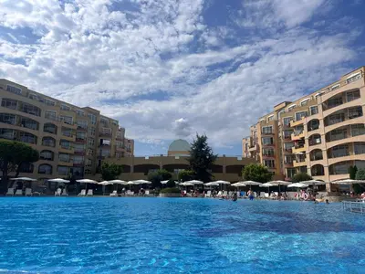 a large pool of blue water with buildings and umbrellas at Black Sea Residence Aheloy in Aheloy