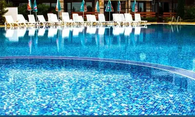 a large swimming pool with chairs and blue water at Gardenia Hills in Sunny Beach