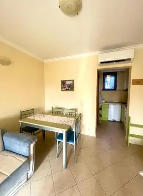 a dining room with a table and a couch at Amarena Studio Santa Marina, Sozopol in Sozopol