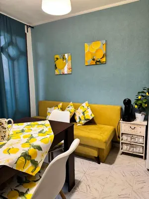 a living room with a table and a yellow couch at Villa Nikoleta in Sveti Vlas