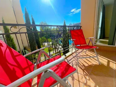 two red chairs sitting on a balcony at Sun and Sea A22 in Sunny Beach