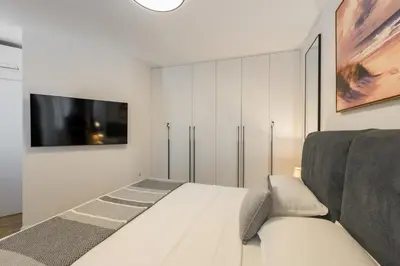 a bedroom with a bed and a tv on a wall at INCANTO Residence in Varna City