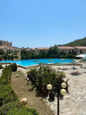 a swimming pool with plants and umbrellas next to it at Apartment 300m from private beach VILA ROMANA Royal Castle in Sveti Vlas