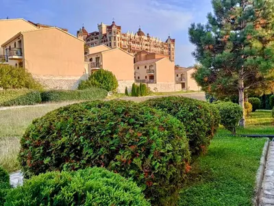 a large house with a large bush in front of it at Apartment 300m from private beach VILA ROMANA Royal Castle in Sveti Vlas