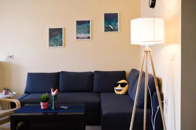 a living room with a blue couch and a table at Sandy Dreams Cozy Studio in Pomorie